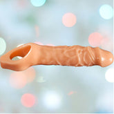 A flesh-colored Mamba Cock Sheath Penis Extender, reminiscent of a playful size upgrade for your furry friend, set against a softly blurred background with pastel circles.